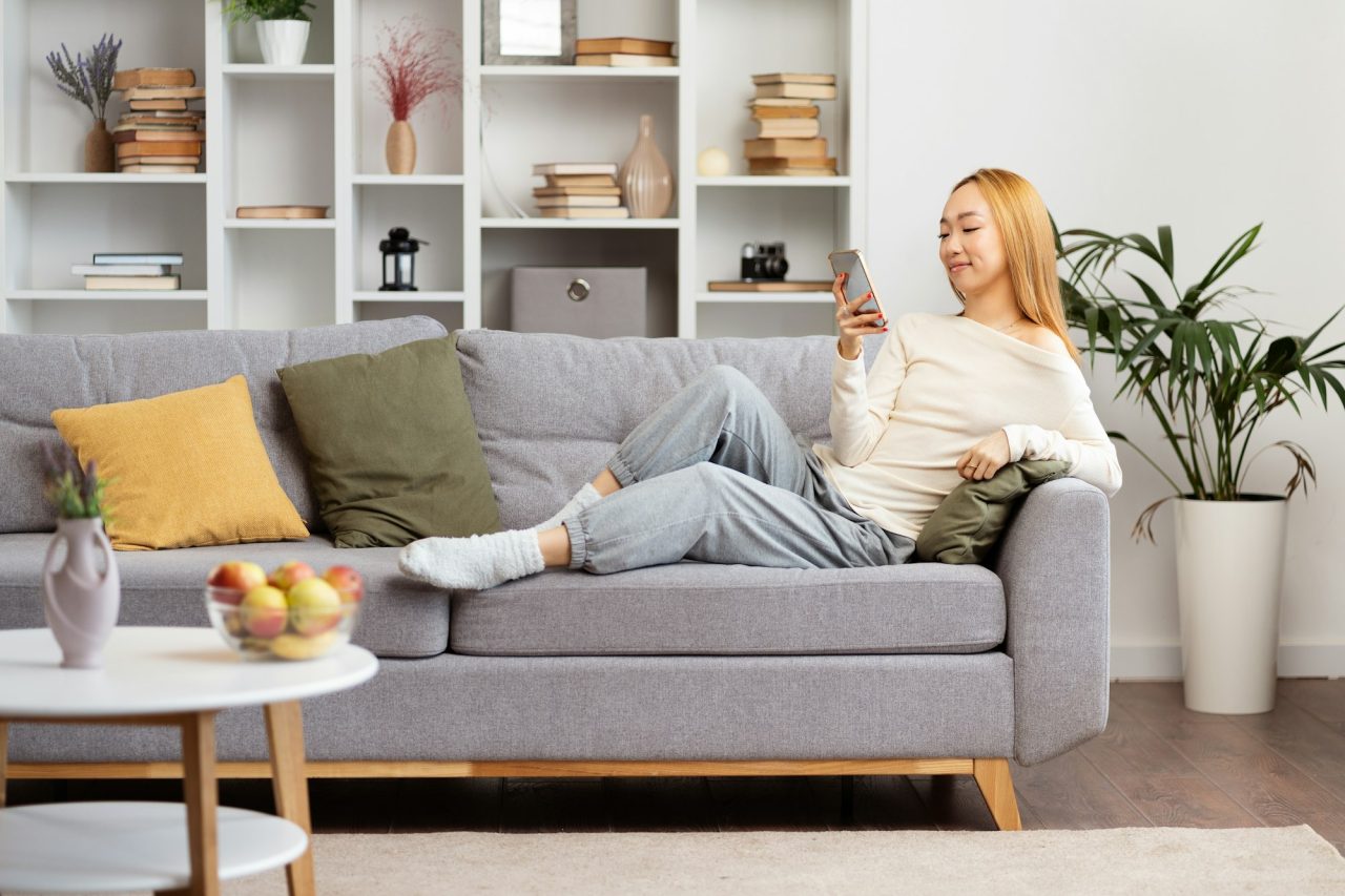 relaxed-young-woman-enjoying-social-media-on-phone-at-home.jpg